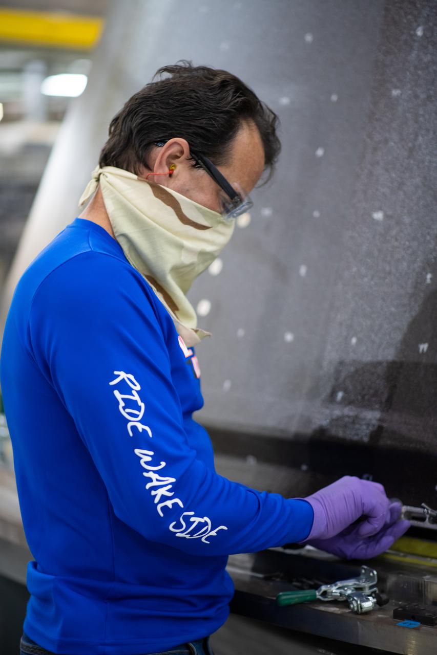 Employees wear personal protective gear at  Michoud Assembly Facility as the facility transitioned to Stage 3 of NASA’s Framework for Return To On-Site Work. Employees wear the appropriate personal protective equipment (PPE) and/or cloth face coverings as required for assigned tasks. Access to the facility is limited to authorized personnel working on mission-critical tasks that must be conducted onsite. Mission-critical tasks include slowly and methodically resuming Space Launch System (SLS) Core Stage and Orion production activities, particularly critical path deliverables to support the Artemis Program, at a pace that limits personnel and follows federal guidelines for social distancing and use of personal protective equipment such as face masks. For more information about SLS, visit nasa.gov/sls.